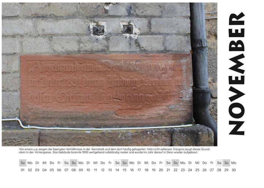 November - Motiv: Von einem u.a. wegen der beengten Verhältnisse in der Kernstadt und dem dort häufig gelagerten Holz nicht seltenem Ereignis zeugt dieser Grundstein in der Hintergasse. Das Gebäude brannte 1890 weitgehend vollständig nieder und wurde im Jahr darauf in Stein wieder aufgebaut.