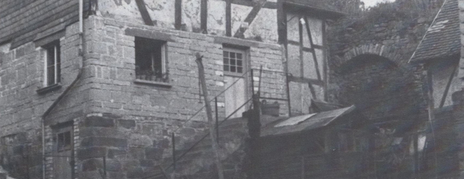 Historisches Foto eines inzwischen verbauten Teilstücks der östlichen Stadtmauer Staufenbergs mit Entlastungsbogen.